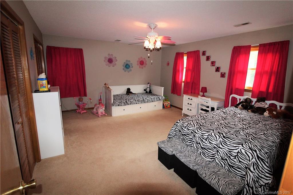 827 Brian Road, Unit 5 Clover, SC 29710 - Photo 10 of 21 a bed room with a bed mirror and a chandelier