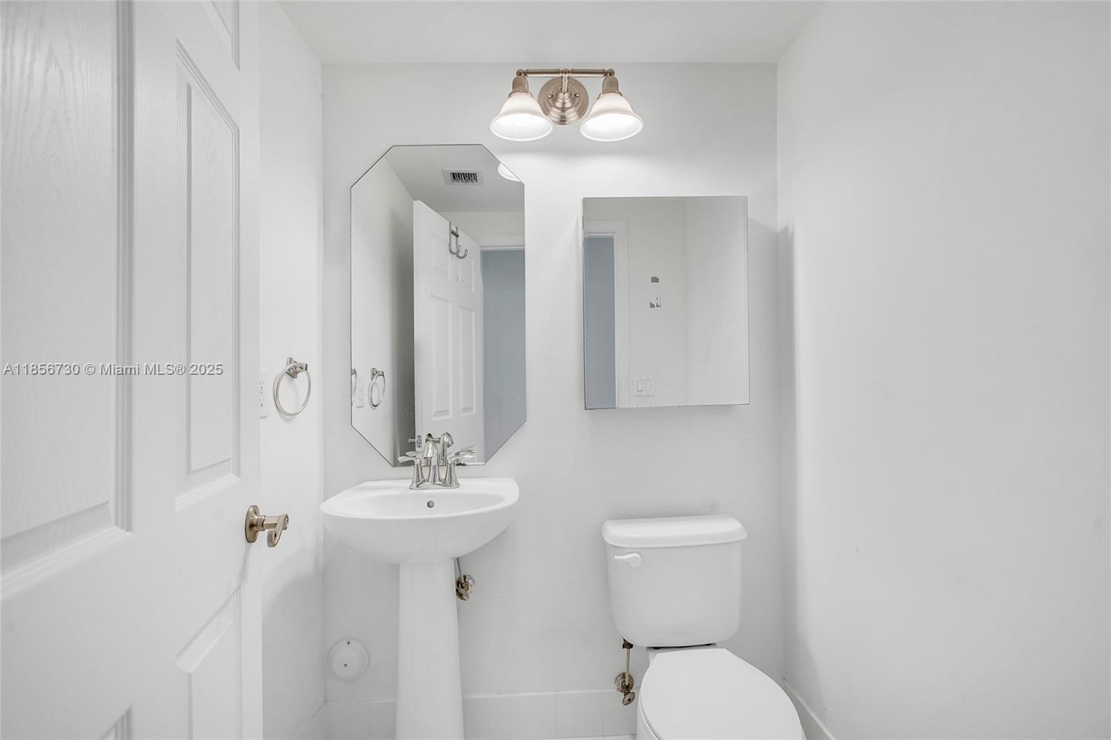 2621 Southwest 120th Terrace, Unit 2032 Miramar, FL 33025 - Photo 11 of 18 a bathroom with a toilet sink and mirror