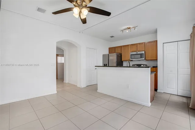 a view of kitchen with cabinets and refrigerator