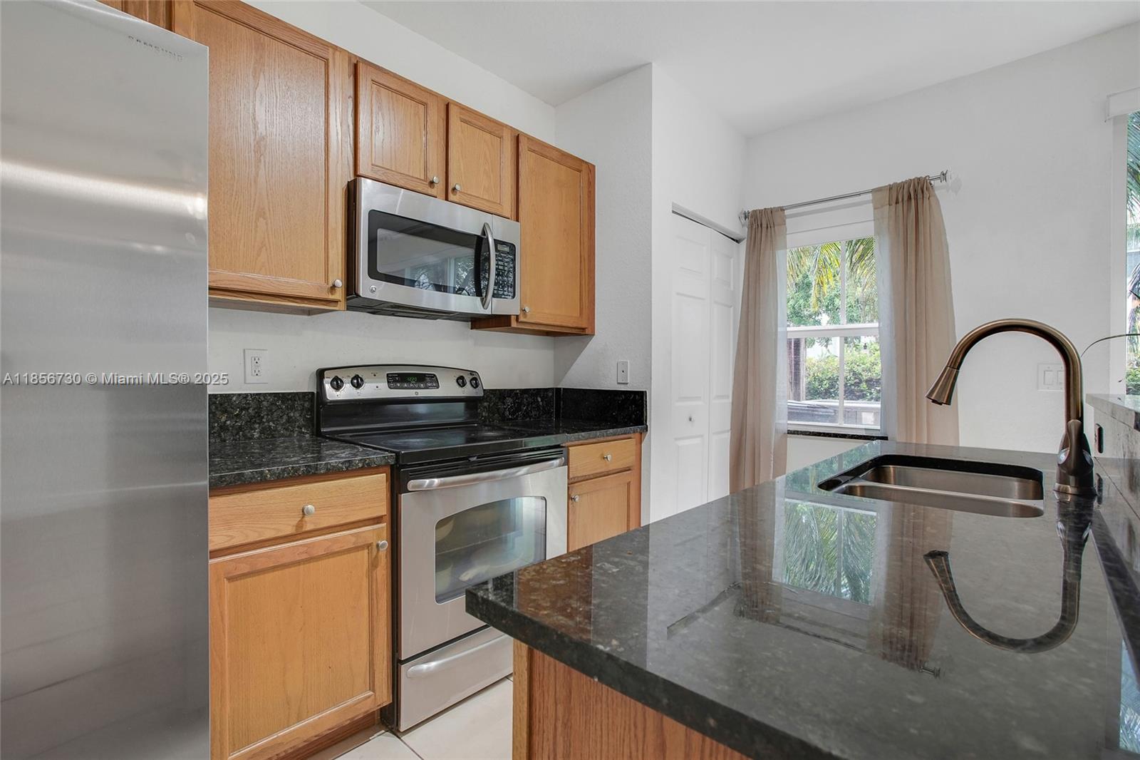 2621 Southwest 120th Terrace, Unit 2032 Miramar, FL 33025 - Photo 17 of 18 a kitchen with granite countertop a sink stainless steel appliances and cabinets