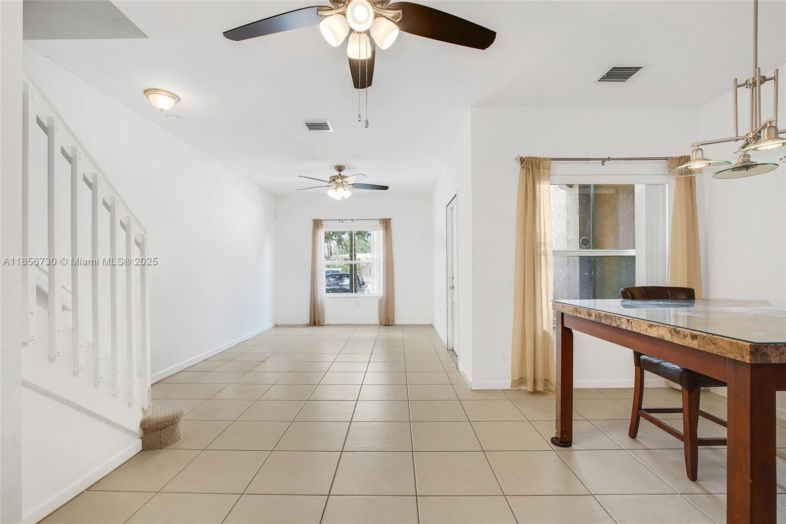 2621 Southwest 120th Terrace, Unit 2032 Miramar, FL 33025 - Photo 2 of 18 a view of an empty room with a chandelier fan and a bathroom