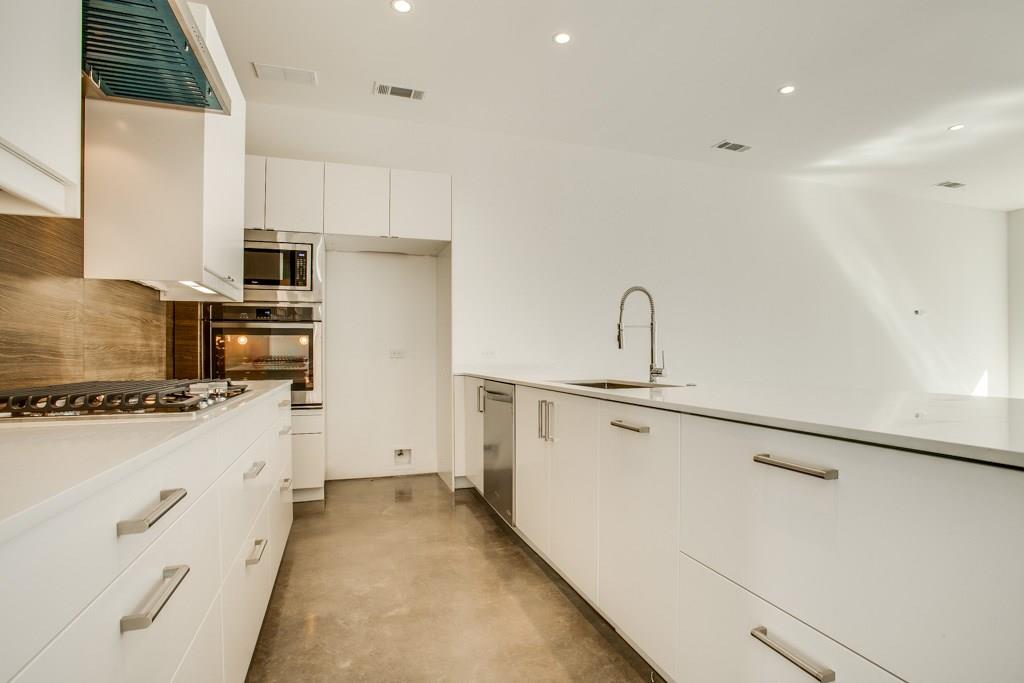 5801 Bryan Parkway Dallas, TX 75206 - Photo 7 of 16 a kitchen with stainless steel appliances a stove refrigerator sink and white cabinets