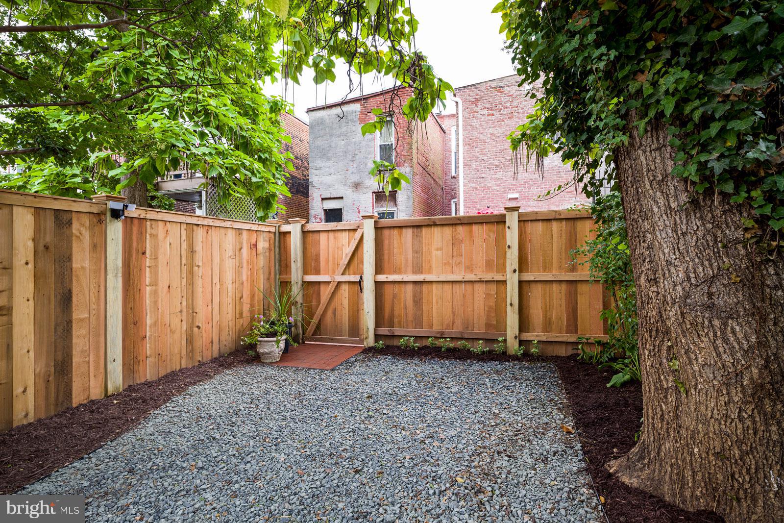 1833 12th Street Northwest Washington, DC 20009 - Photo 26 of 30 a view of a backyard with wooden fence and a large tree