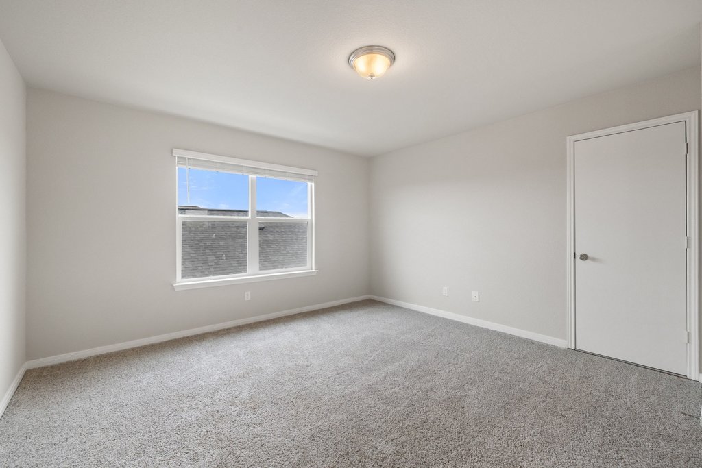 102 Ashford Way Georgetown, TX 78626 - Photo 17 of 28 A well-lit bedroom with fresh, neutral tones offers a versatile foundation for any personal style.