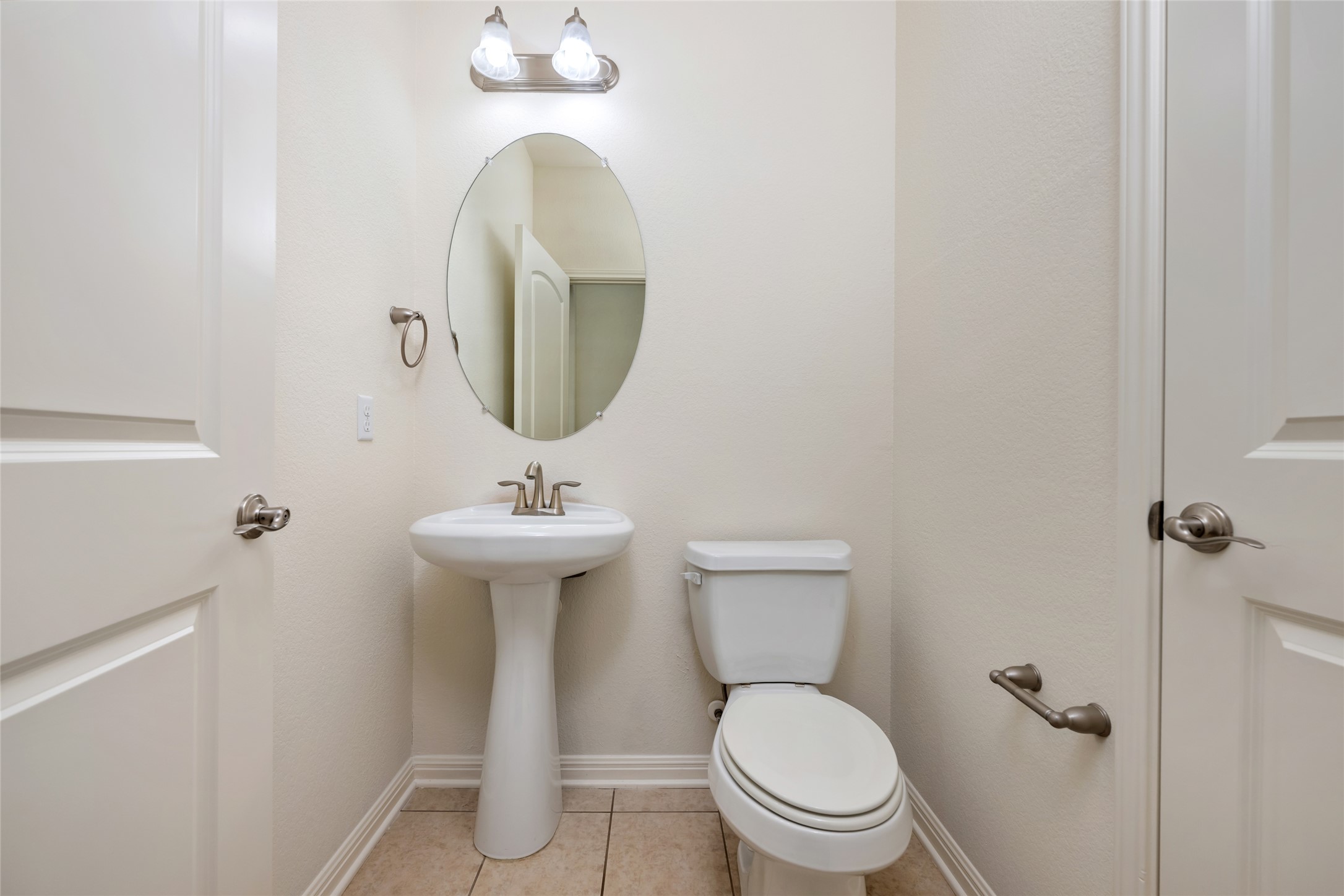 15205 Spillman Ranch Loop Austin, TX 78738 - Photo 27 of 40 A compact and functional bathroom features a sleek pedestal sink and tiled flooring.