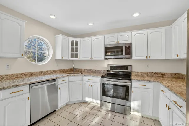 a kitchen with cabinets stainless steel appliances and a sink
