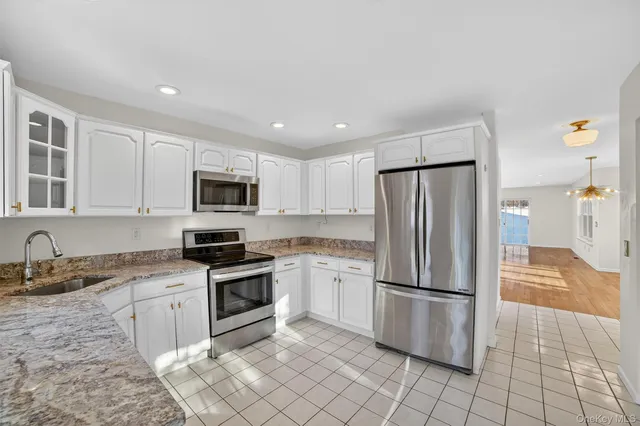 a kitchen with kitchen island stainless steel appliances a stove refrigerator and microwave