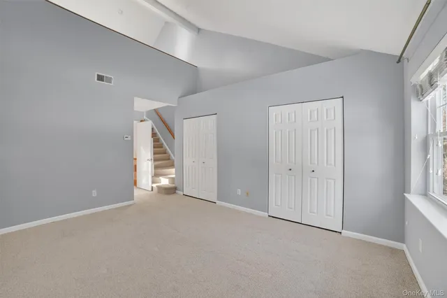 a spacious bedroom with a bed and cabinet