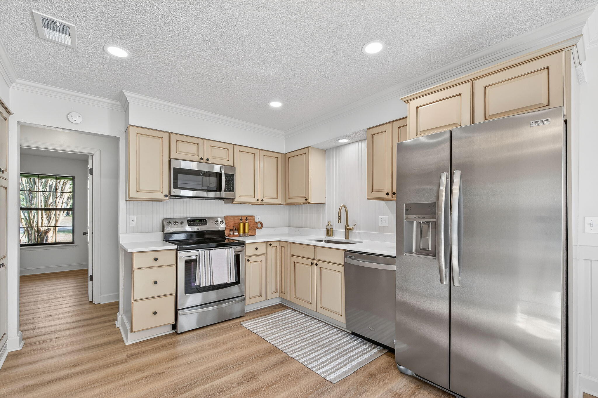 932 Ridgewood Way Niceville, FL 32578 - Photo 4 of 47 a kitchen with stainless steel appliances granite countertop a refrigerator a stove and a sink with wooden floor