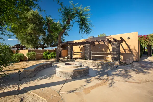 a patio with a table and chairs and a fire pit