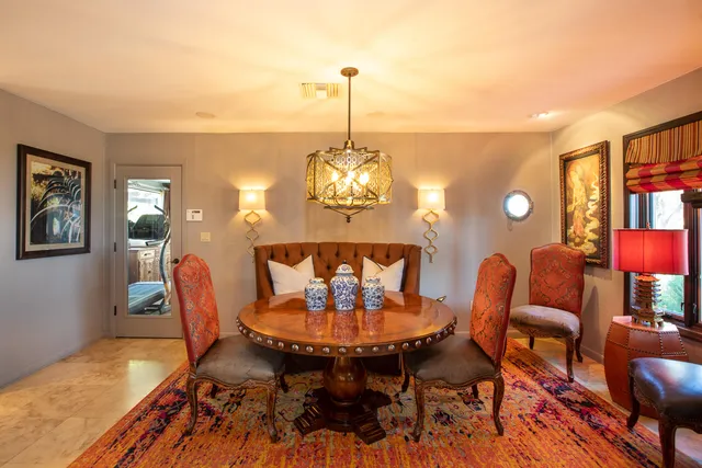 a dining room with furniture a chandelier and wooden floor