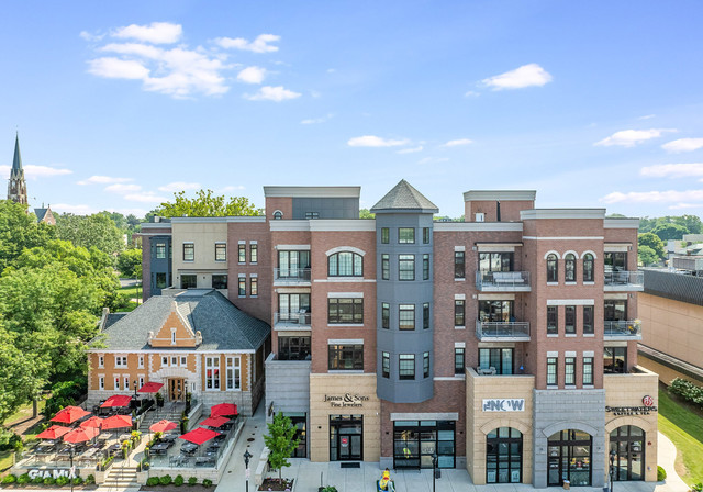110 South Washington Street, Unit 400 Naperville, IL 60540 - Photo 1 of 54 a front view of multi story residential apartment building with yard and retail shops