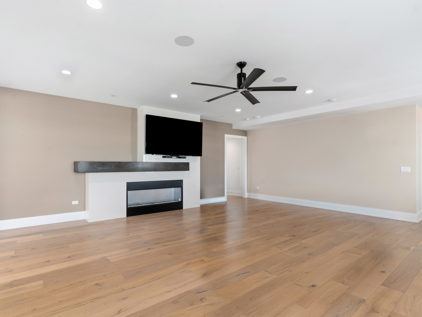 110 South Washington Street, Unit 400 Naperville, IL 60540 - Photo 9 of 54 a view of a livingroom with a flat screen tv a ceiling fan and wooden floor