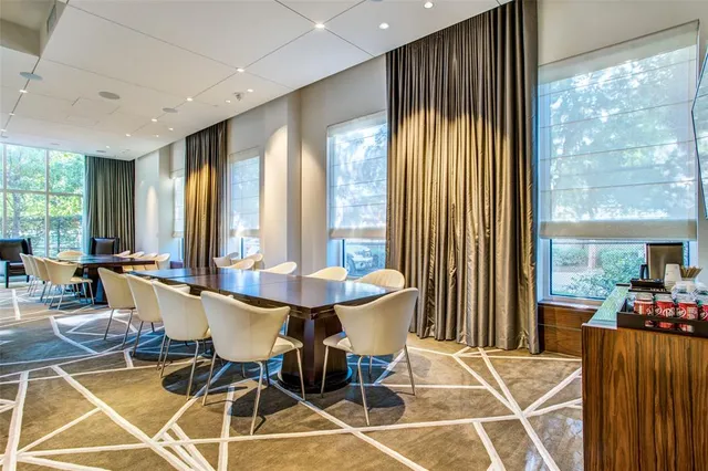 a dining room with furniture and large windows