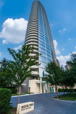 a front view of a multi story residential apartment building with yard and parking space