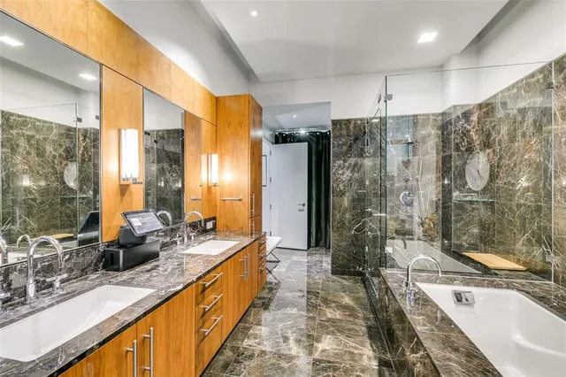 a large bathroom with a tub a sink shower and mirror