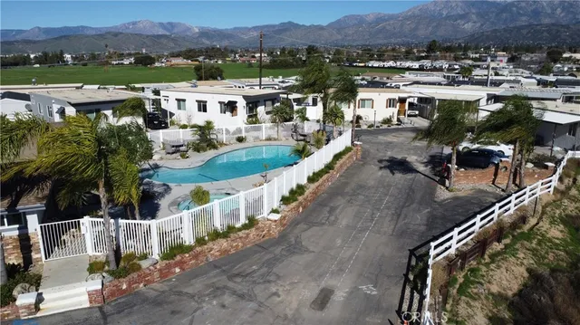 an aerial view of a city with lots of residential buildings ocean and mountain view in back