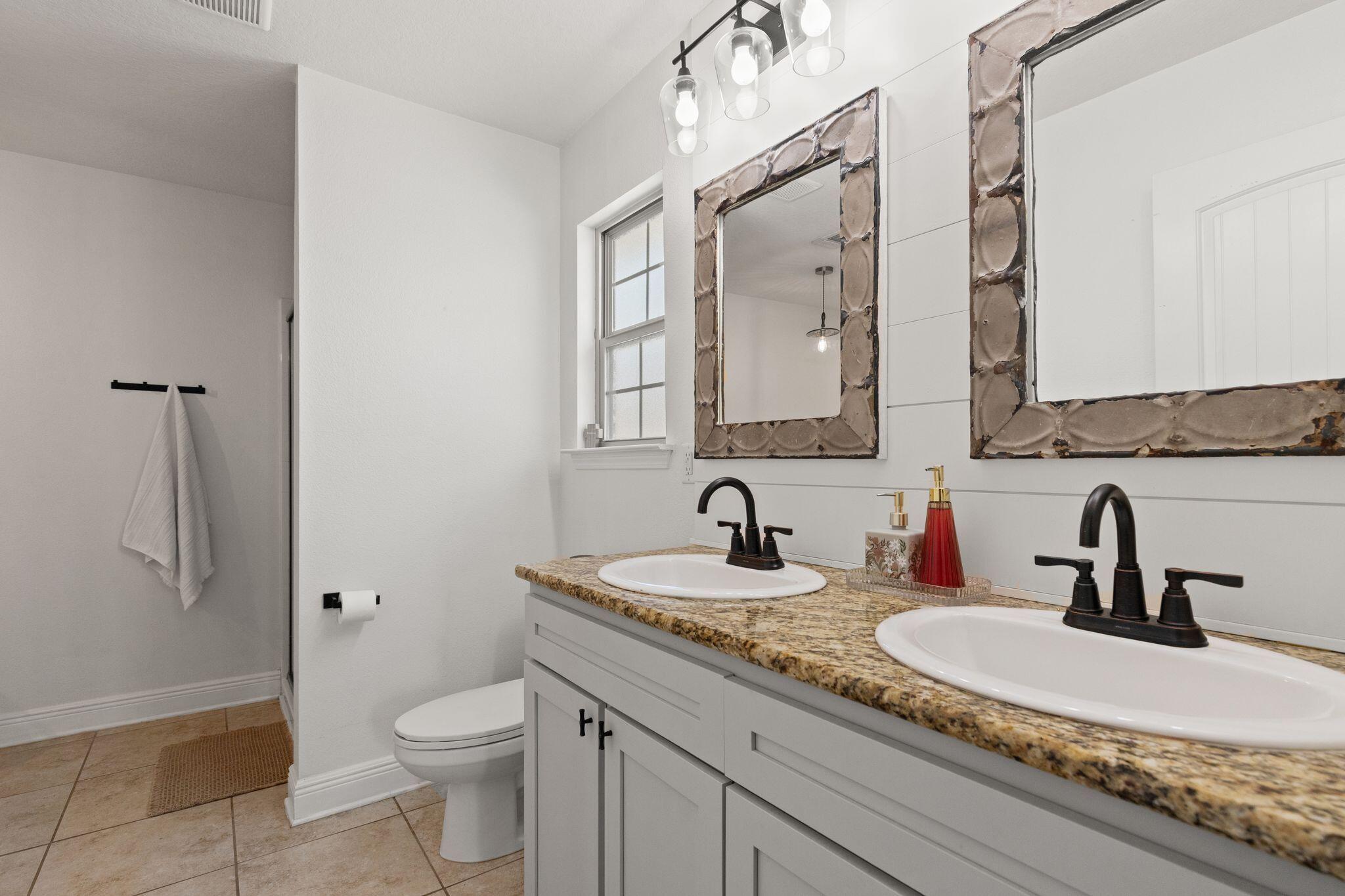 10 Golden Eagle Court Santa Rosa Beach, FL 32459 - Photo 19 of 36 a bathroom with a granite countertop sink a toilet and a mirror