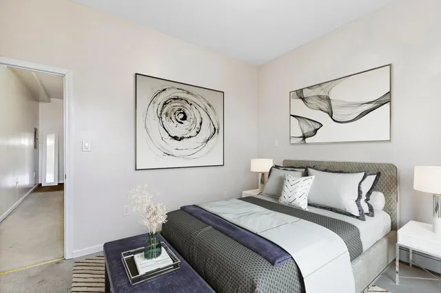 a bedroom with a bed and a painting on the wall