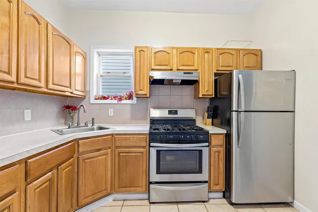 a kitchen with stainless steel appliances granite countertop a refrigerator and a sink