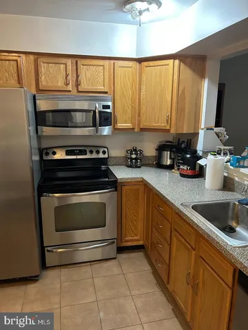 a kitchen with stainless steel appliances a stove sink and cabinets