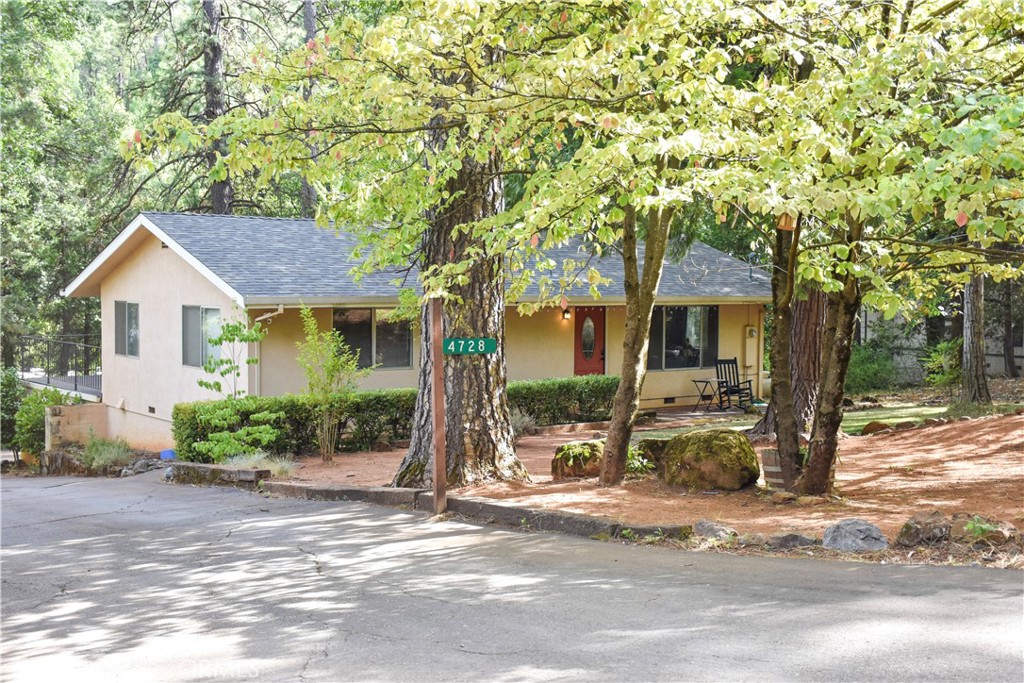 a front view of a house with a yard and potted plants