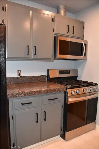 a kitchen with stainless steel appliances granite countertop a sink and a stove