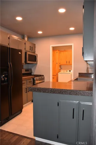 a kitchen with stainless steel appliances granite countertop a refrigerator and a sink