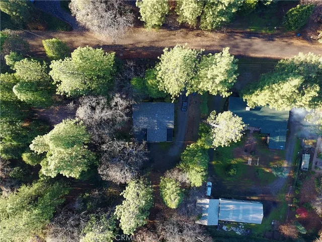a aerial view of a house with a yard and large trees