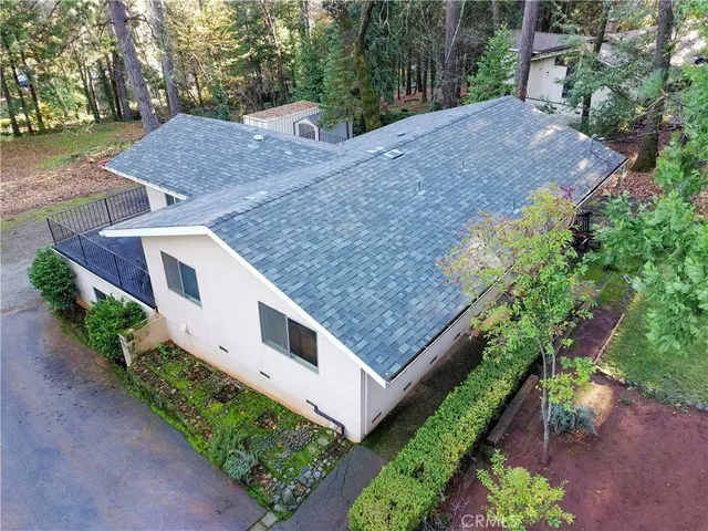 a backyard of a house with table and chairs under an umbrella