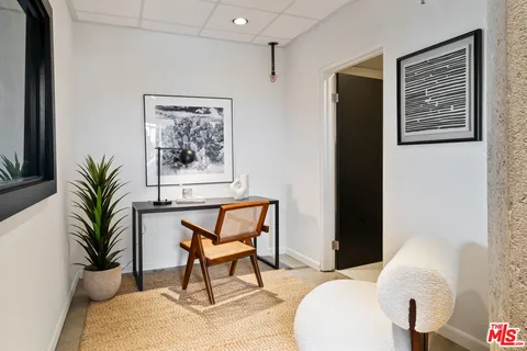 a view of a hallway with wooden floor and a bathroom