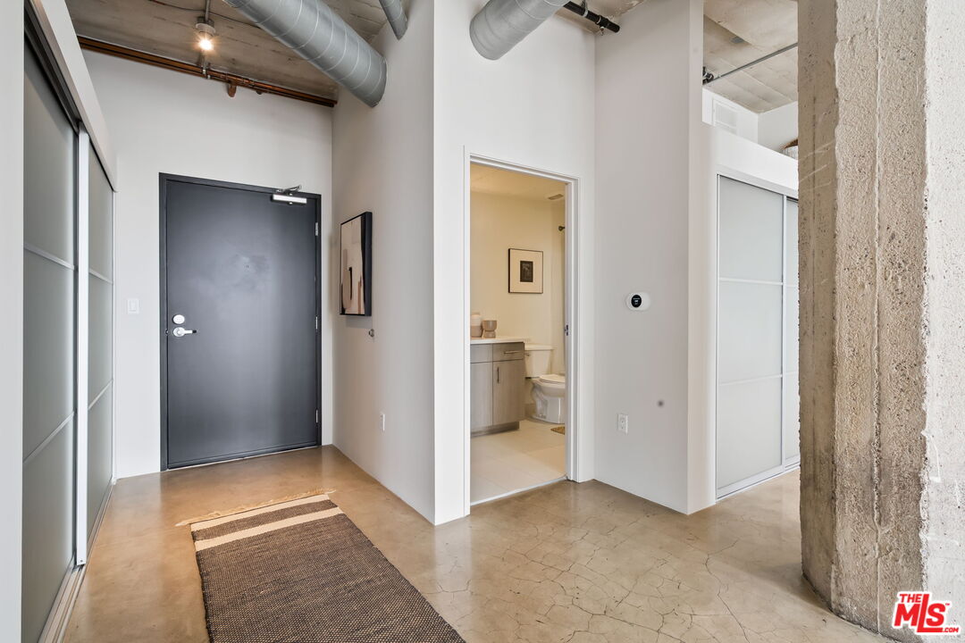 825 East 4th Street, Unit 310 Los Angeles, CA 90013 - Photo 21 of 33 a view of a hallway with wooden floor and a bathroom