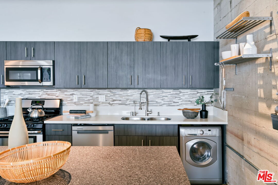 825 East 4th Street, Unit 310 Los Angeles, CA 90013 - Photo 5 of 33 a kitchen with a sink a stove and cabinets