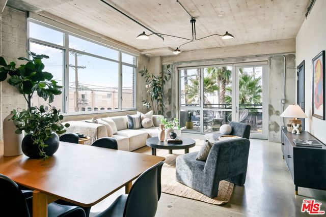a living room with furniture potted plant and a large window