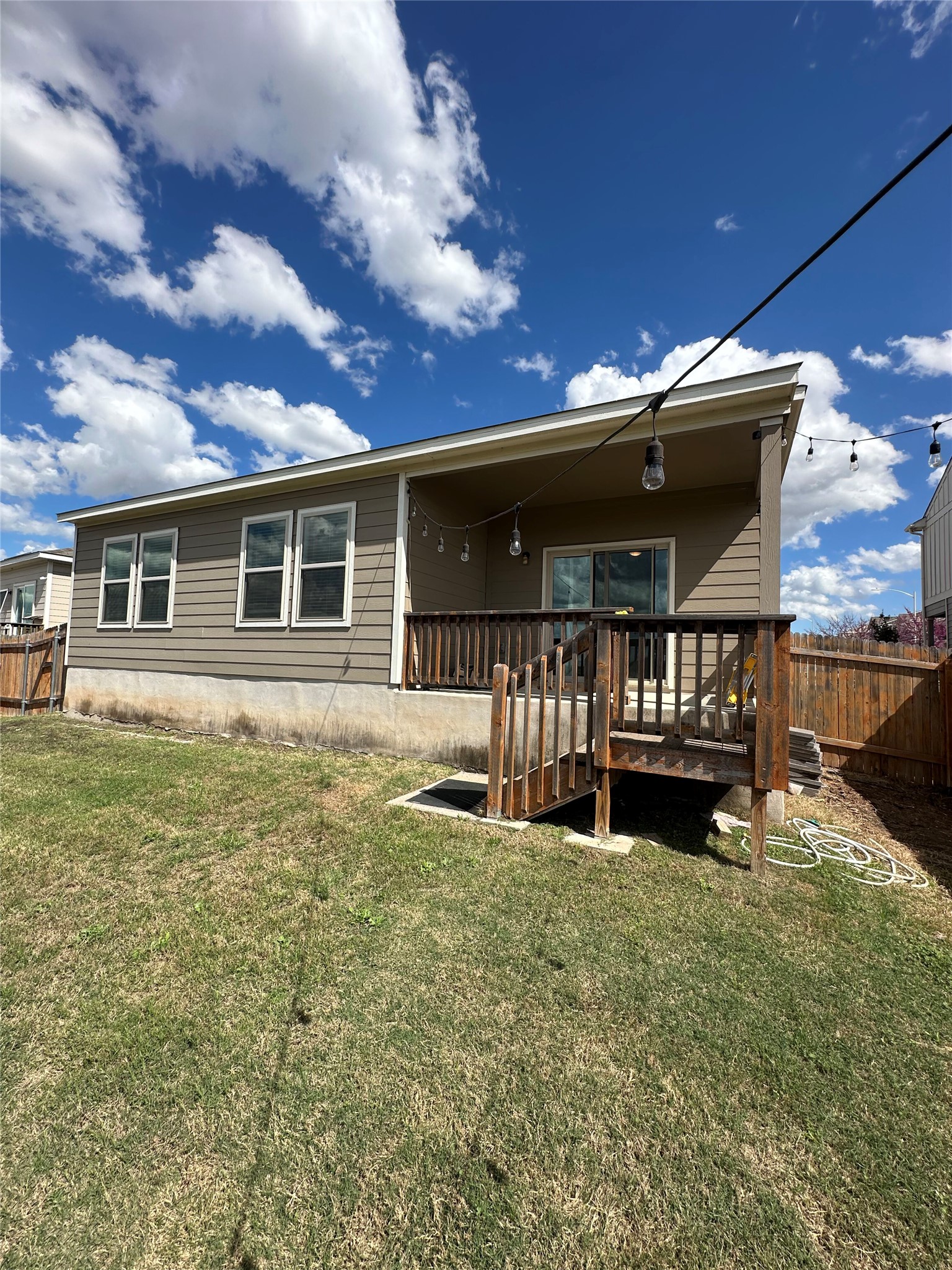 13000 Titanium Street Austin, TX 78754 - Photo 15 of 15 Rear exterior featuring a covered deck with railings, wood-finish stairs, and a sliding glass door