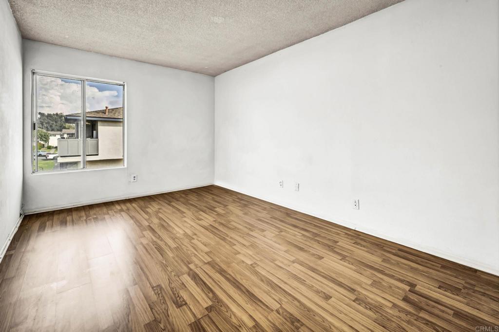 3448 Seabreeze Walk Oceanside, CA 92056 - Photo 17 of 29 an empty room with wooden floor and windows