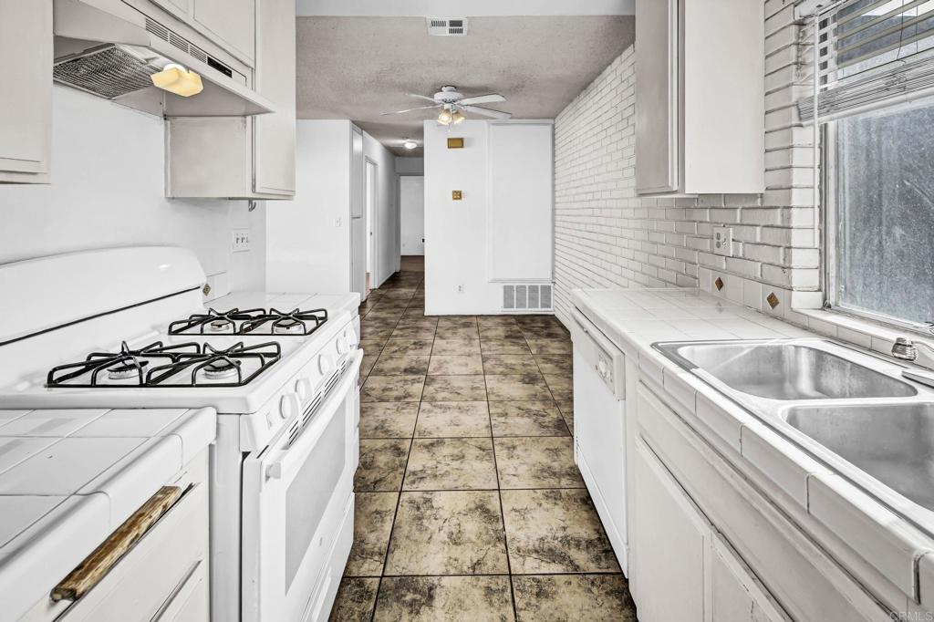3448 Seabreeze Walk Oceanside, CA 92056 - Photo 10 of 29 a kitchen with a sink stove and refrigerator