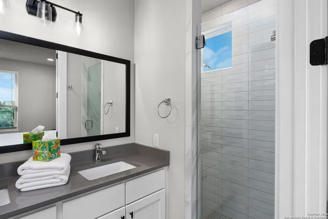 a bathroom with a granite countertop toilet sink and mirror