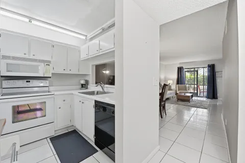 a kitchen with white cabinets and white appliances