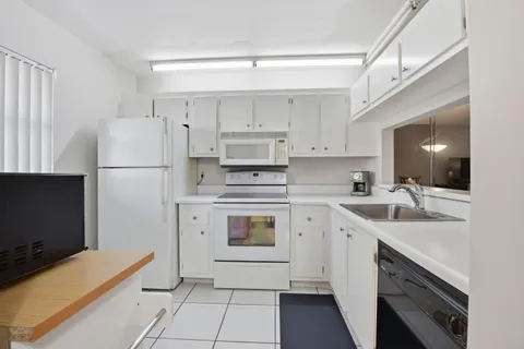 a kitchen with cabinets stainless steel appliances and a sink