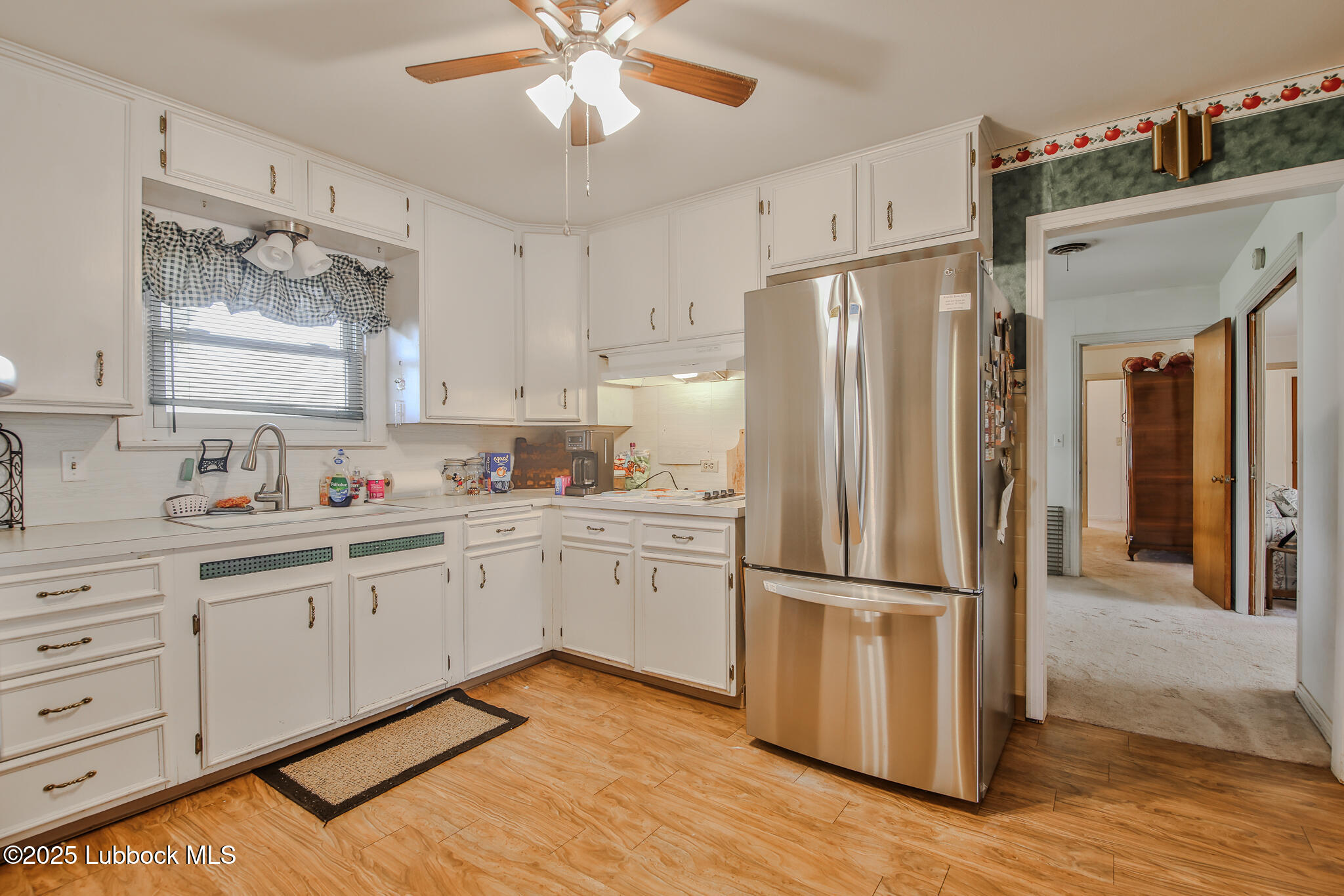 515 East 16th Street Littlefield, TX 79339 - Photo 6 of 32 a kitchen with white cabinets and stainless steel appliances