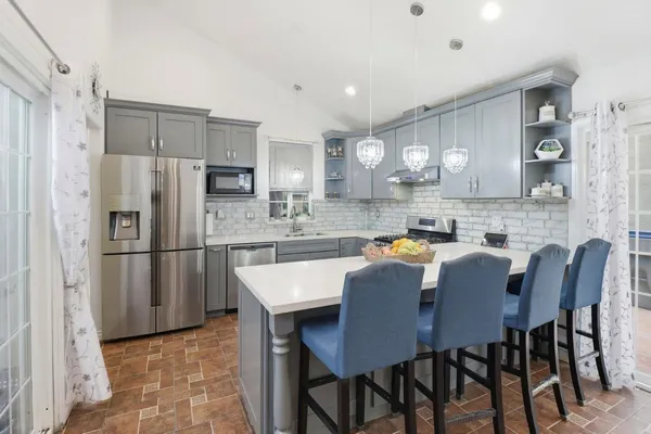 a kitchen with refrigerator dining table and chairs