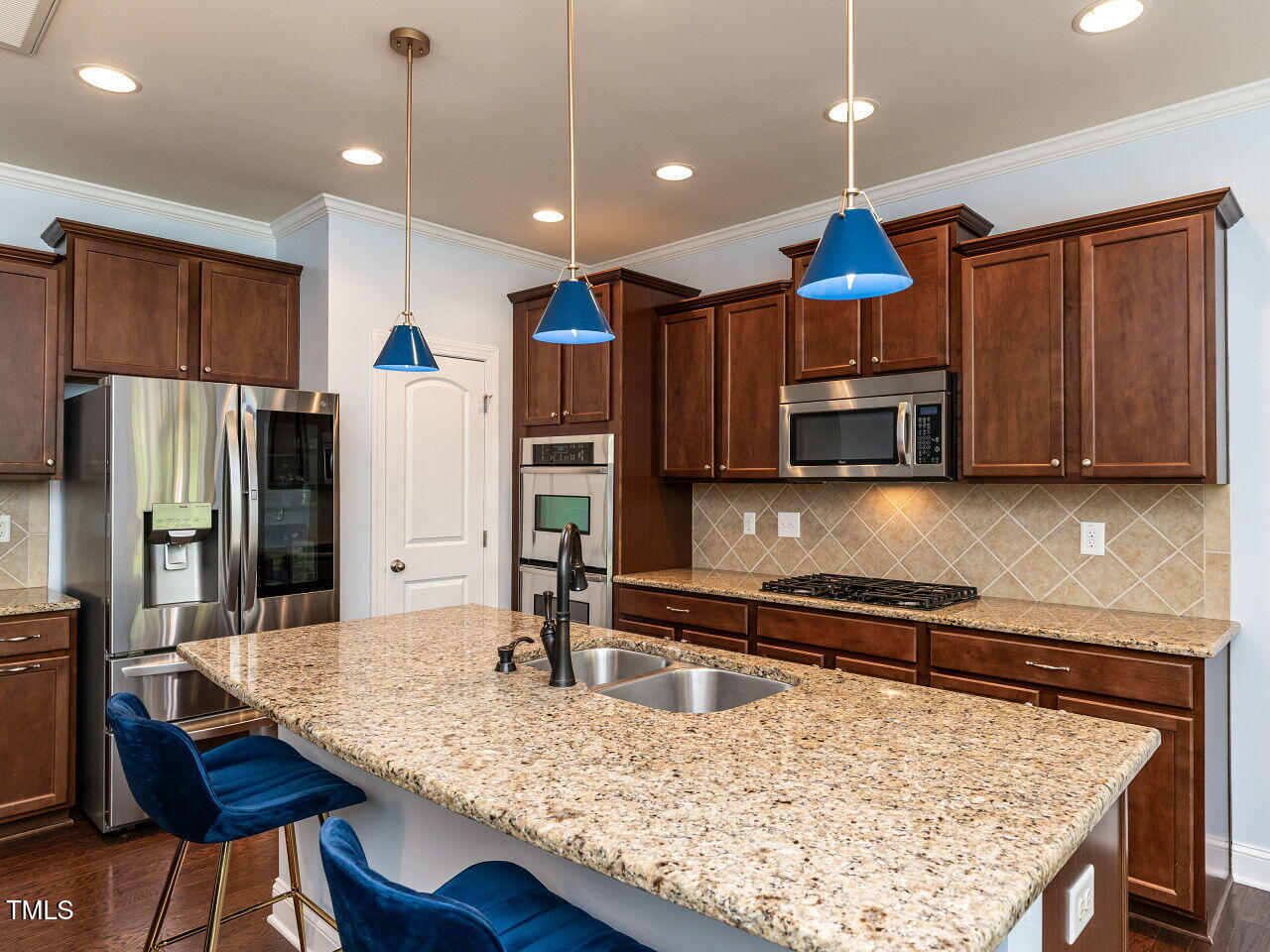 112 Victorian Oaks Drive Durham, NC 27713 - Photo 10 of 32 a kitchen with stainless steel appliances kitchen island granite countertop a table chairs in it and wooden floors