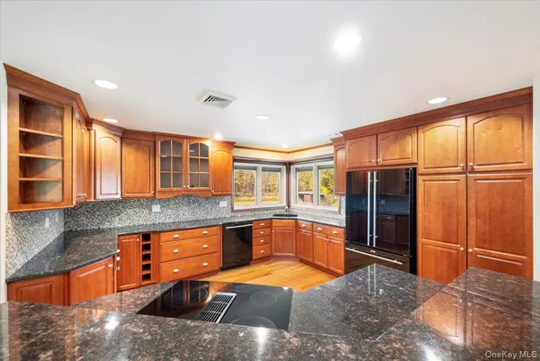 a large kitchen with stainless steel appliances granite countertop a refrigerator and a sink