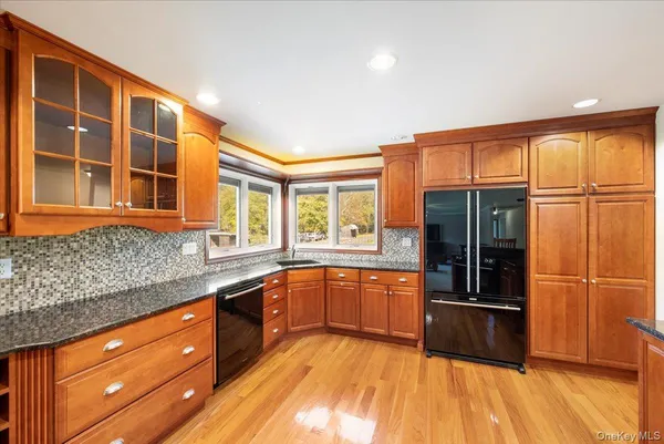a large kitchen with stainless steel appliances granite countertop a refrigerator and a sink