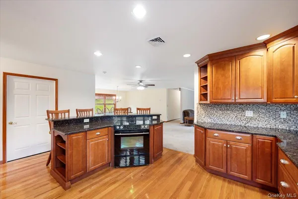 a kitchen with stainless steel appliances granite countertop a stove and a wooden cabinets