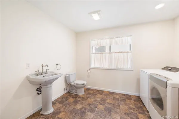 a bathroom with a sink mirror and a toilet