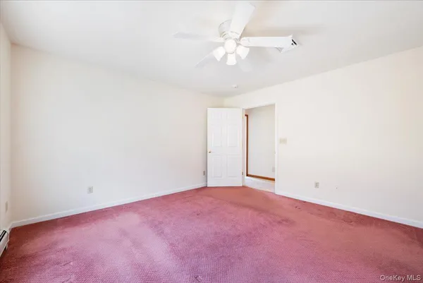 an empty room with a ceiling fan and a window