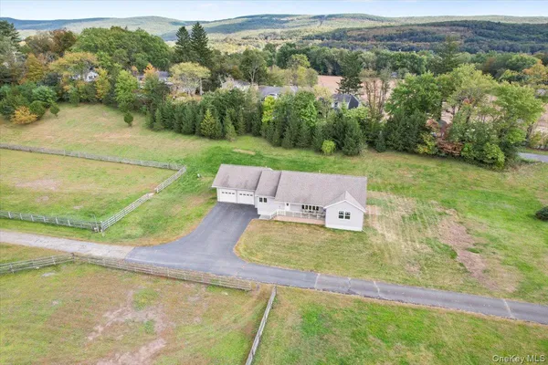 an aerial view of a house with yard swimming pool and mountain view