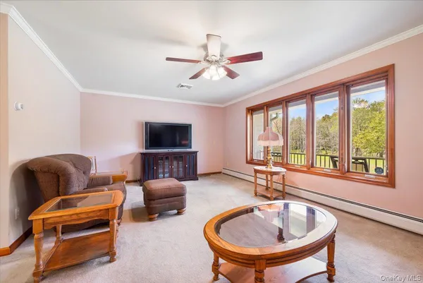 a living room with furniture a flat screen tv and a large window